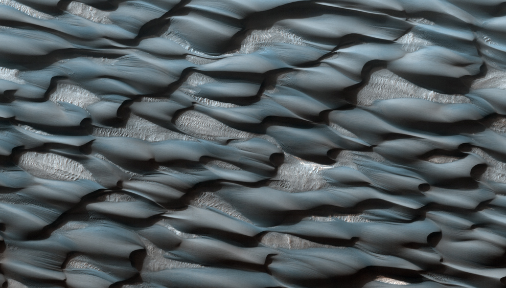 Part of the Abalos Undae dune field. The sands appear blueish because of their basaltic composition, while the lighter areas are probably covered in dust. More, or see location on Google Mars. (NASA/JPL/University of Arizona)