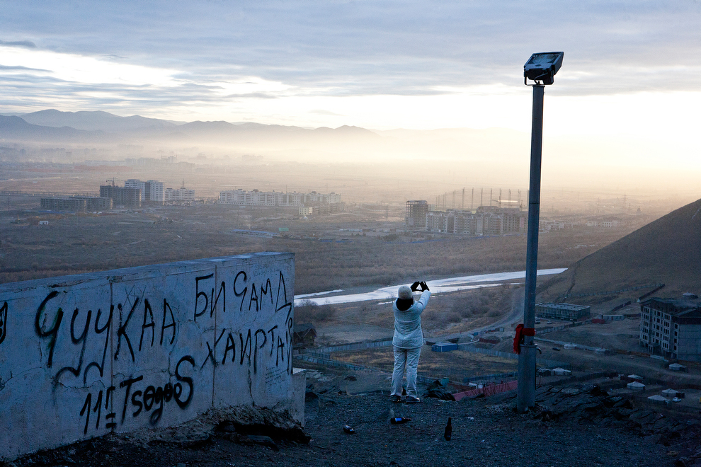 Толгодоос Улаанбаатар хотыг харж зогсож байгаа эмэгтэй. 2011 оноос Монголын эдийн засаг өсөж байна.