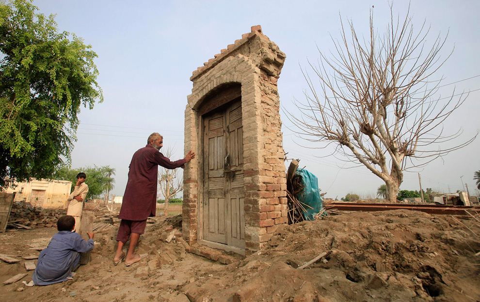 Mohammad Ramzan, a flood victim, places his hand on the door that was left after his house was washed away by flood in the Mehmood Kot village in Muzaffargarh district of Pakistan's Punjab province September 3, 2010. (REUTERS/Faisal Mahmood)