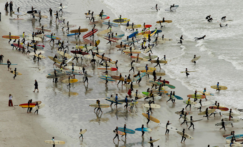 South African surfers take to the water in an attempt to break the Guinness World Record for the highest number of riders on a single wave at Muizenberg in Cape Town, September 26, 2010. (REUTERS/Mike Hutchings)